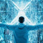 Man with outstretched arms stands in front of digital light display.